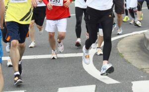 マラソン大会で大勢で走ってる足元の画像